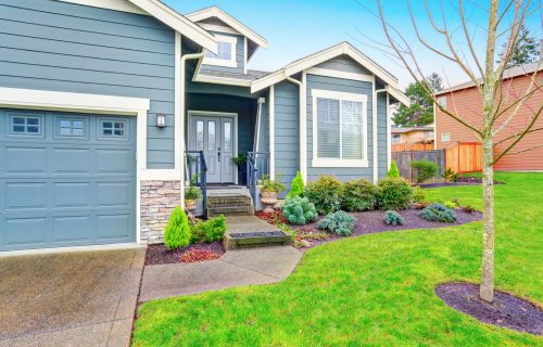Curb appeal. House exterior with blue trim, garage and driveway