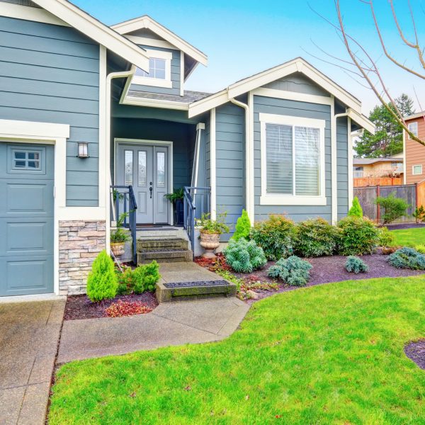 Curb appeal. House exterior with blue trim, garage and driveway